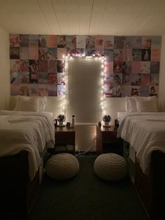 two twin beds in a room with lights on the wall and pictures above them,