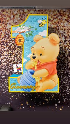 a winnie the pooh birthday card hanging on a wall with confetti around it