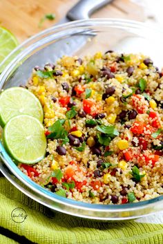 a bowl filled with rice and vegetables next to lime wedges on a green towel