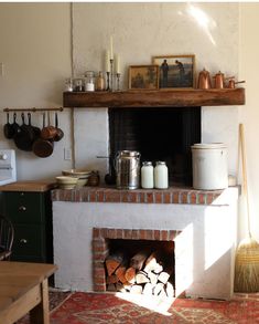 a fireplace in a kitchen with pots and pans on the mantel above it