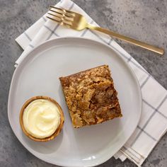 a white plate topped with dessert next to a fork