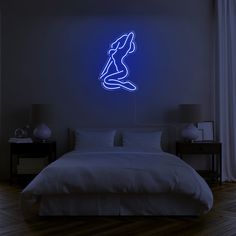 a bed in a room with a lit up neon sign on the wall above it