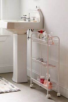 a bathroom sink sitting next to a stand with soaps and lotions on it