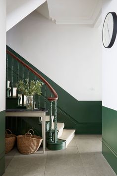 a clock on the wall next to a staircase