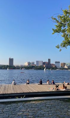 people are sitting on the dock by the water