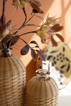 two vases with flowers in them sitting on a table