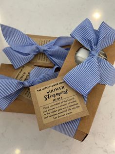 two blue and white striped bow ties in a brown box with label on the front