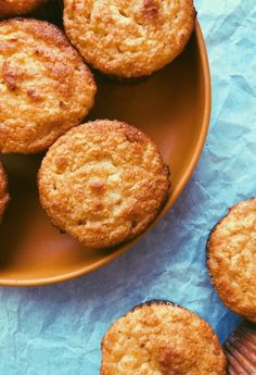 some muffins are on a plate next to other muffins