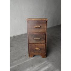 an old wooden chest of drawers on concrete floor