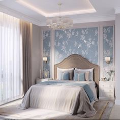 a bedroom with blue and white wallpaper, a chandelier and a bed