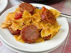 a plate with pasta and sausage on it