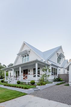 a large white house with lots of windows on the front and side of it's porch