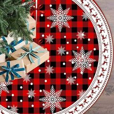 a red and black plaid christmas plate with presents on it next to a small tree