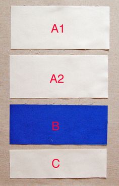 three strips of white paper with red and blue tape on them