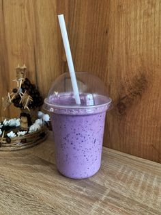 a purple drink sitting on top of a wooden table