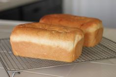 two loaves of bread sitting on a cooling rack