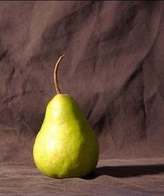 a green pear sitting on top of a wooden table