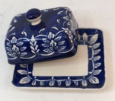 two blue and white dishes with designs on the top one has a square plate underneath it