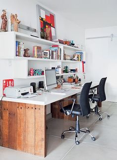 a desk with two computers on it in a room