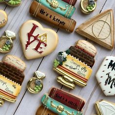 decorated cookies are laid out on a white wooden surface, with the letters and symbols painted on them