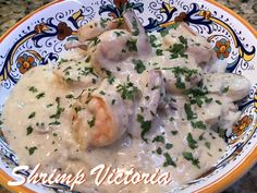 a bowl filled with shrimp and gravy on top of a table