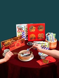 two people holding chopsticks over a bowl of food on top of a table