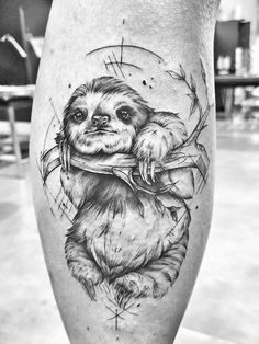 a black and white photo of a sloth on the leg