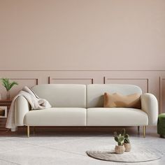 a white couch sitting next to a potted plant