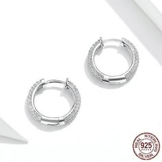 These stunning sterling silver cubic zircon hoop earrings are a beautiful addition to a ladies' outfit. Every piece is beautifully arranged and made with a 925 sterling silver high polished finish covered with zircon stones and comes packed in a Cycolinks gift bag. ✔️ FREE Worldwide shipping, we ship to over 250 Countries! ✔️ 925 sterling silver, platinum-plated, 3 layer electroplating to last! ✔️ Weight - 1.6g pair ✔️ Connection type: Simple ear clip ✔️ The materials are 925 sterling silver env White Gold Huggie Earrings With Sparkling Cubic Zirconia, White Gold Hoop Earrings With Cubic Zirconia, White Gold Cubic Zirconia Hoop Earrings For Pierced Ears, White Gold Cubic Zirconia Hoop Earrings, Small Hoop Sterling Silver Earrings In Diamond White, Silver Cubic Zirconia Small Hoop Earrings, Silver Huggie Earrings With Cubic Zirconia, Small Hoop Silver Cubic Zirconia Earrings, Dazzling Silver Cubic Zirconia Huggie Earrings