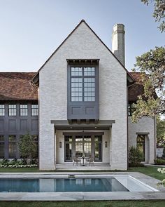 a house with a pool in front of it and an outdoor dining area next to it