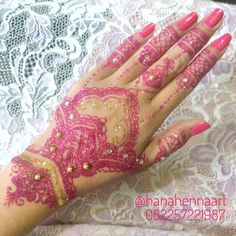 a woman's hand with pink and gold hendi