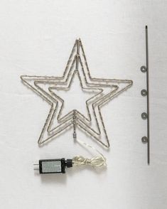 a wire star ornament next to a sewing needle