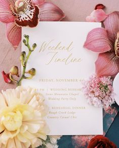 the wedding stationery is surrounded by flowers