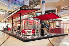 the interior of a shopping mall with red booths and black and white checkered flooring