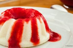 a white plate topped with a dessert covered in red sauce