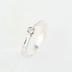 a white gold and silver ring with a diamond in the center on a white background