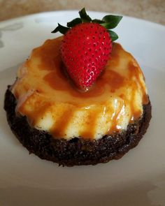 a chocolate cookie with a strawberry on top and caramel sauce drizzled over it