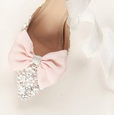 a pair of shoes with bows and pearls on them