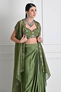 Mehendi green cape with cutdana, bead, sequin embroidery in floral pattern on cutwork border. Paired with sleeveless embroidered padded blouse and draped skirt. - Aza Fashions Green Designer Dress With Cape Sleeves, Designer Green Dress With Cape Sleeves, Party Choli With Cape Sleeves And Floral Embroidery, Party Choli With Floral Embroidery And Cape Sleeves, Floral Embroidered Choli With Cape Sleeves For Parties, Green Cape Sleeves Dress For Festive Occasion, Green Festive Dress With Cape Sleeves, Elegant Sleeveless Green Choli, Green Dresses With Cape Sleeves For Festive Occasions