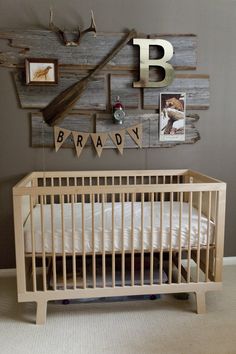 a baby's room is decorated in wood and has pictures on the wall