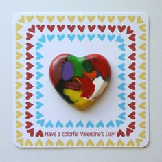 a heart shaped brooch sitting on top of a greeting card that says have a colorful valentine's day