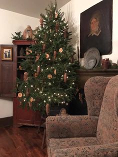 a living room with a christmas tree in the corner and an old fashioned chair next to it