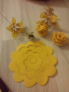 some yellow flowers are sitting on the floor next to each other and one is cut out from felt