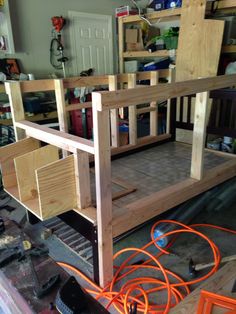 a wooden bunk bed sitting on top of a floor next to a pile of tools