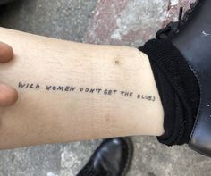 a person with a tattoo on their arm that says wild women don't get the blues