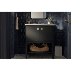 a bathroom with a sink, mirror and black tiled walls in the background is an open door