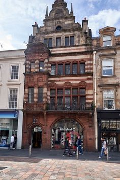 people walking in front of an old building