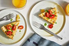 two white plates topped with slices of pizza next to oranges and glasses of juice