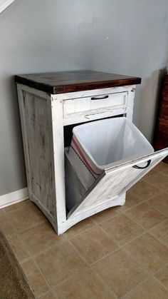 an old cabinet with a trash can in it