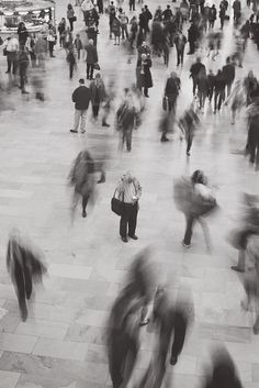 a crowd of people walking across a tiled floor